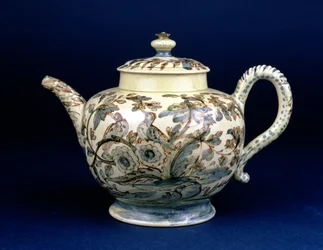Staffordshire Creamware-Teekanne, bekannt als die Tunstall-Teekanne, dekoriert mit drei Vögeln in orientalischem Laubwerk, bemalt in bräunlichem Mangan, die Umrisse in Blau und Grün unterglasur von F. Morg